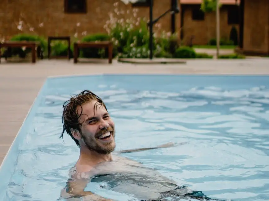smiling man swimming in pool of resort