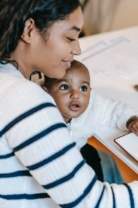 indian female with baby near notepad at table